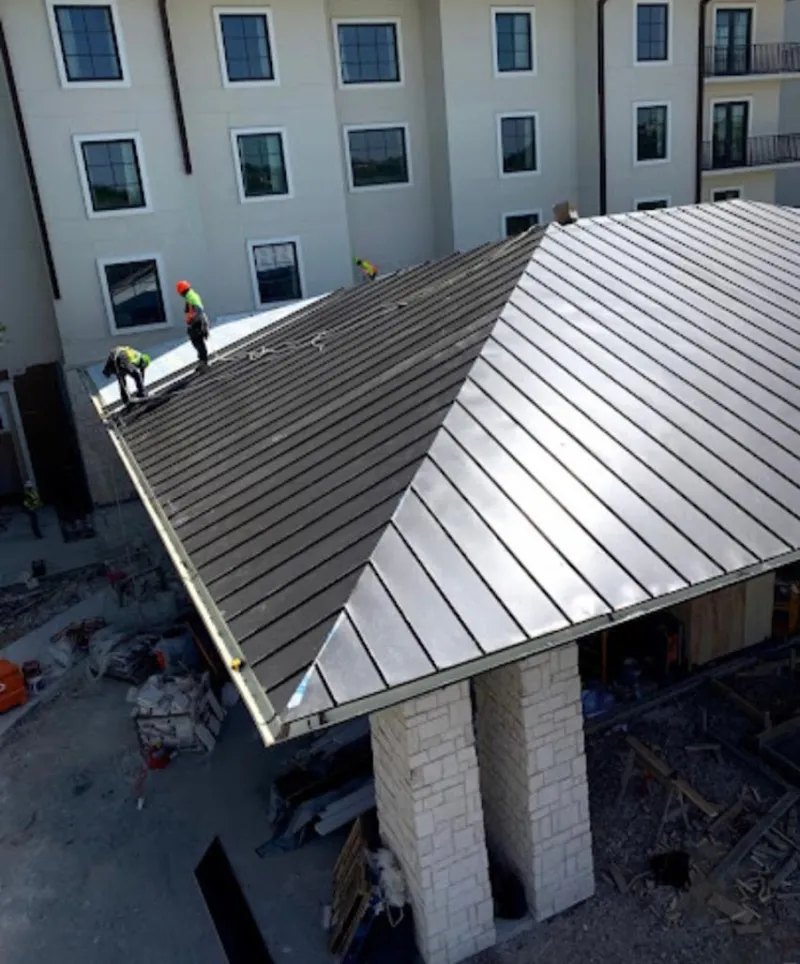 Crew installing standing seam metal roof panels on a commercial project in Aquia Harbour